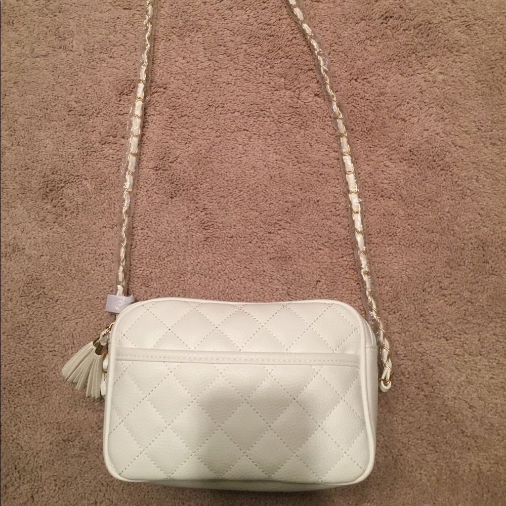 A white/crime crossbody. Has gold chain detail